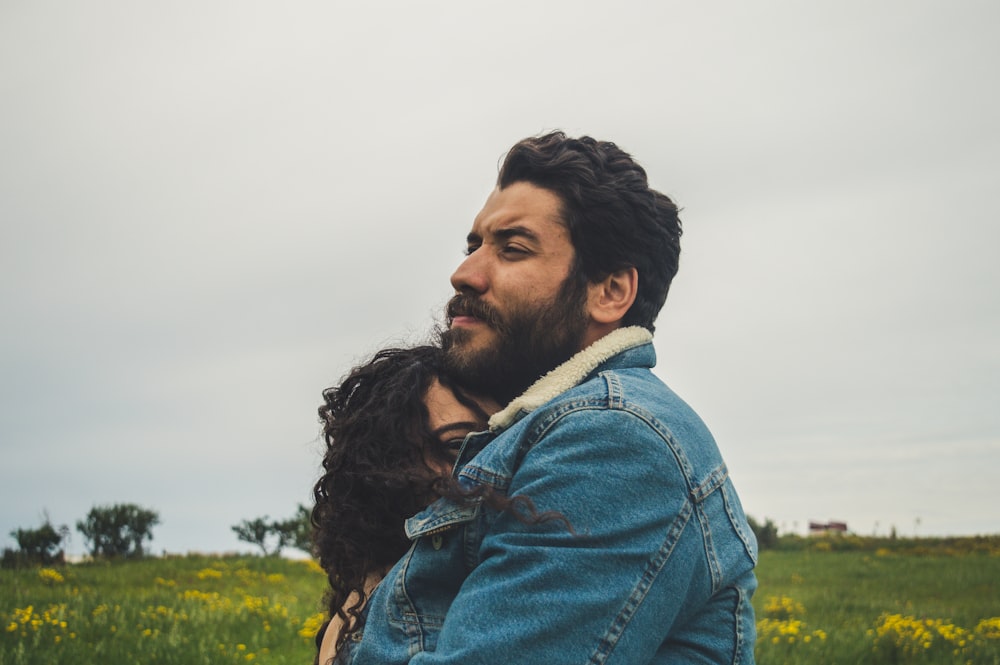 man and woman hugging on focus photography