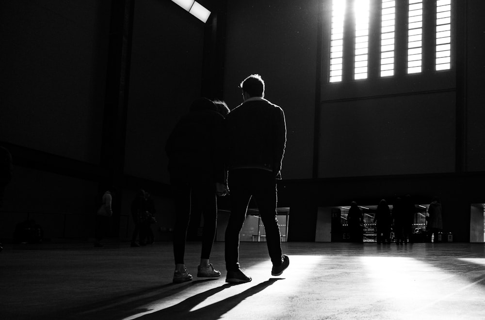 silhouette photography of man and woman standing inside building