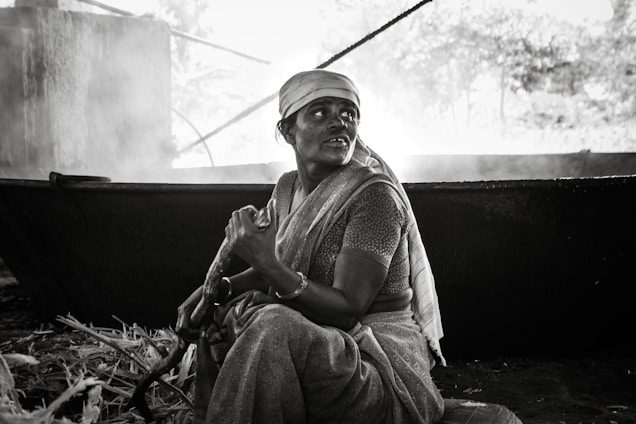 A warm kitchen scene showing women farmers carefully preparing traditional Nepali pickles in small batches.