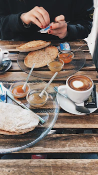 A cozy breakfast scene with bread, jam, and coffee bathed in morning light.