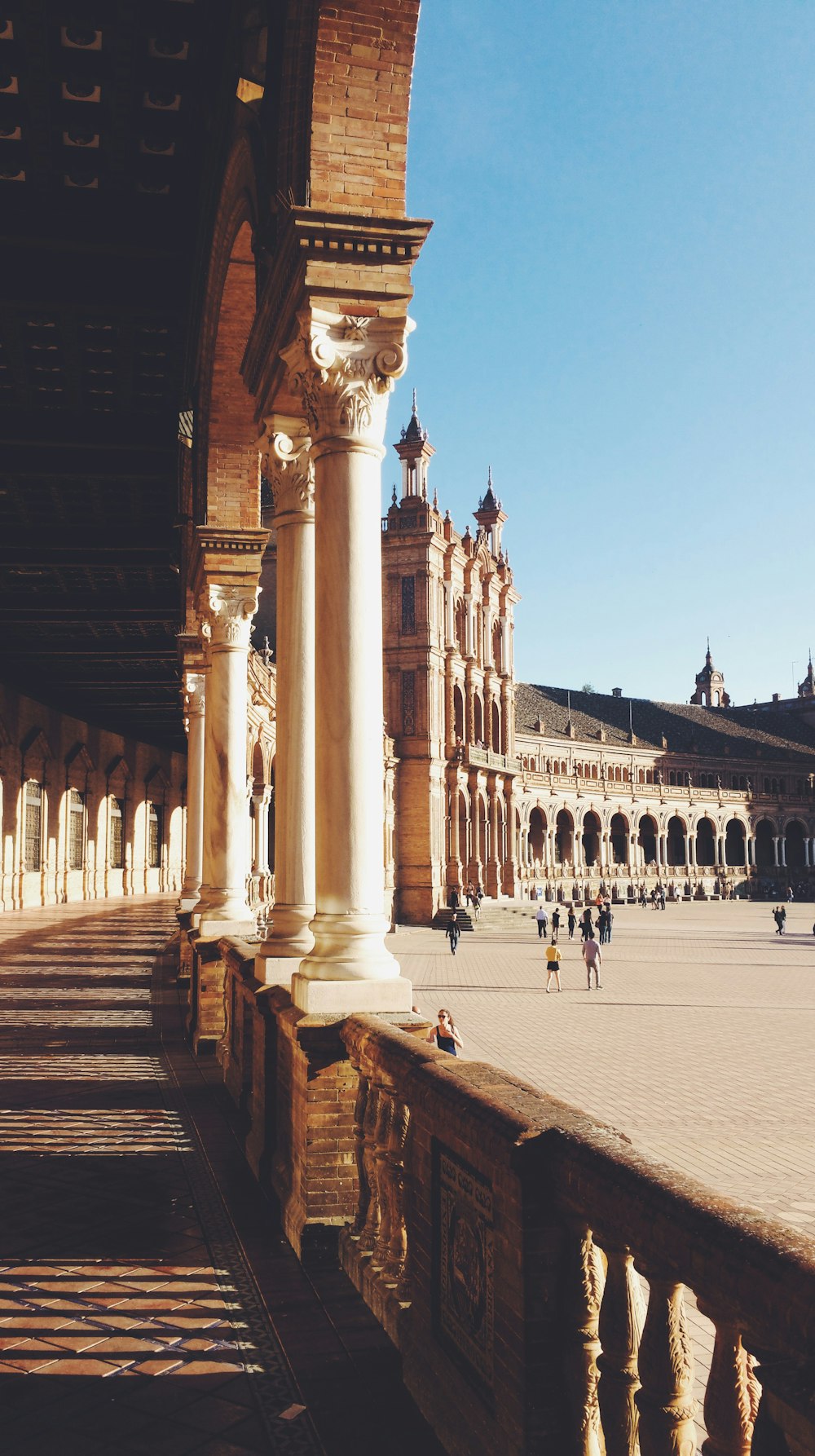 a large building with columns and people walking around it