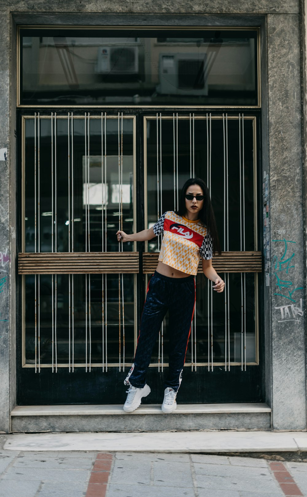 woman in black and red tracking pants standing in front of gate