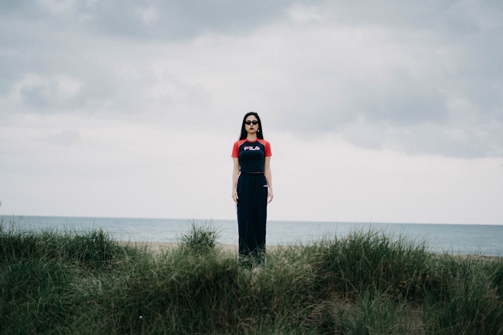 woman standing on grass field under gray gray