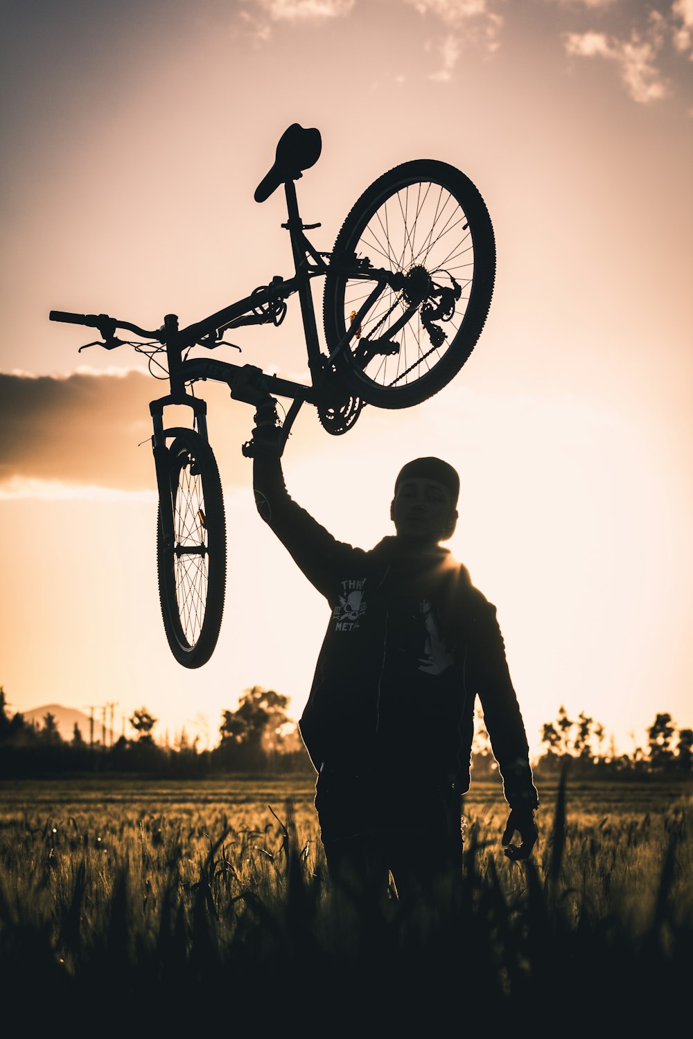 man carrying bike at frassfield during golden hour