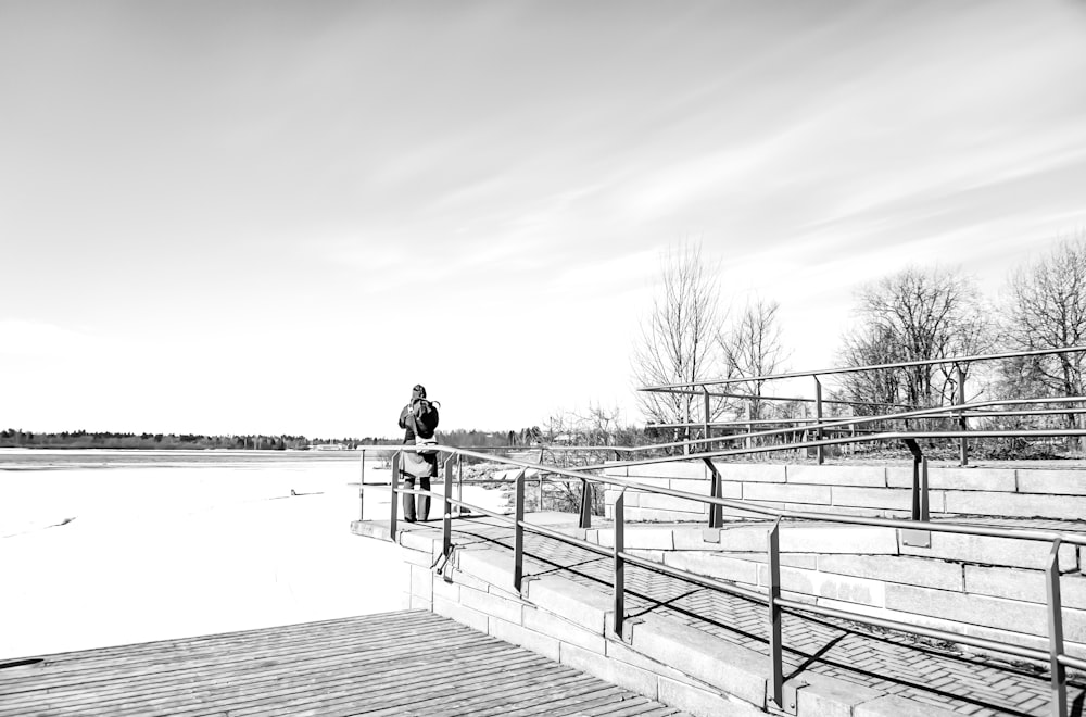 man standing beside railings