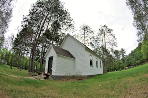 A peaceful country chapel surrounded by blooming flowers on a bright spring day.