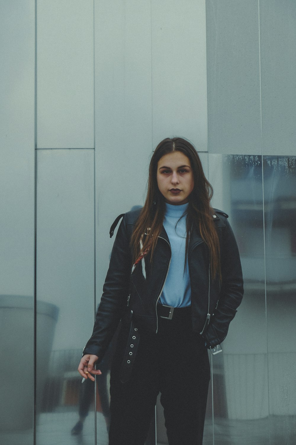 Mujer con chaqueta sosteniendo un cigarrillo