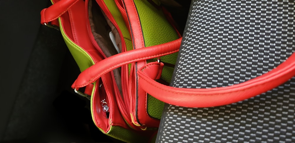 grüne und rote Ledertasche unter dem Autositz