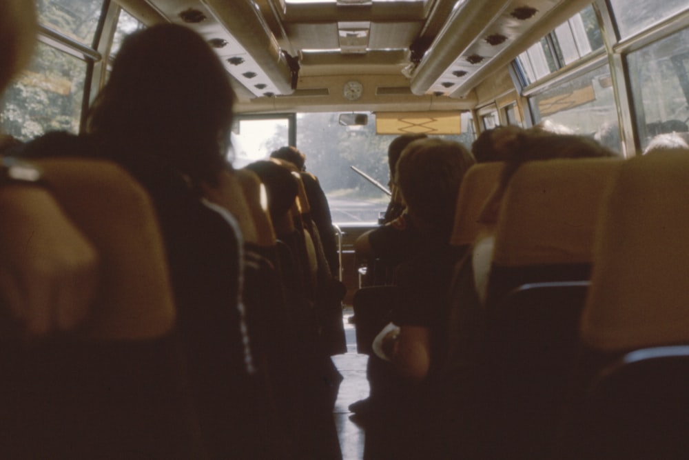 pessoas sentadas enquanto andam de ônibus