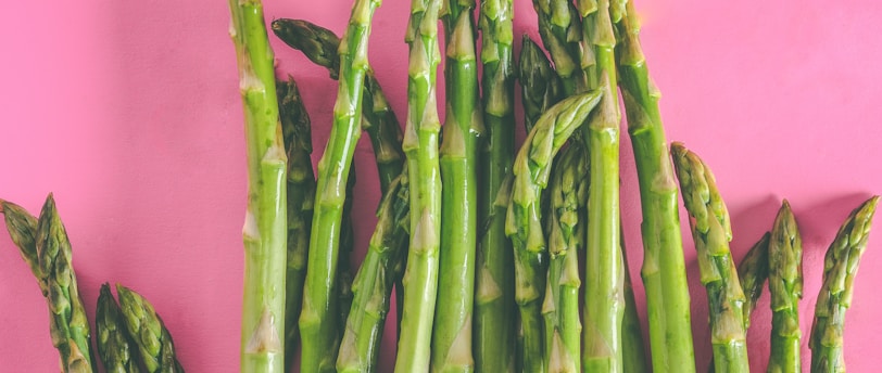 green asparagus vegetables on pink surface
