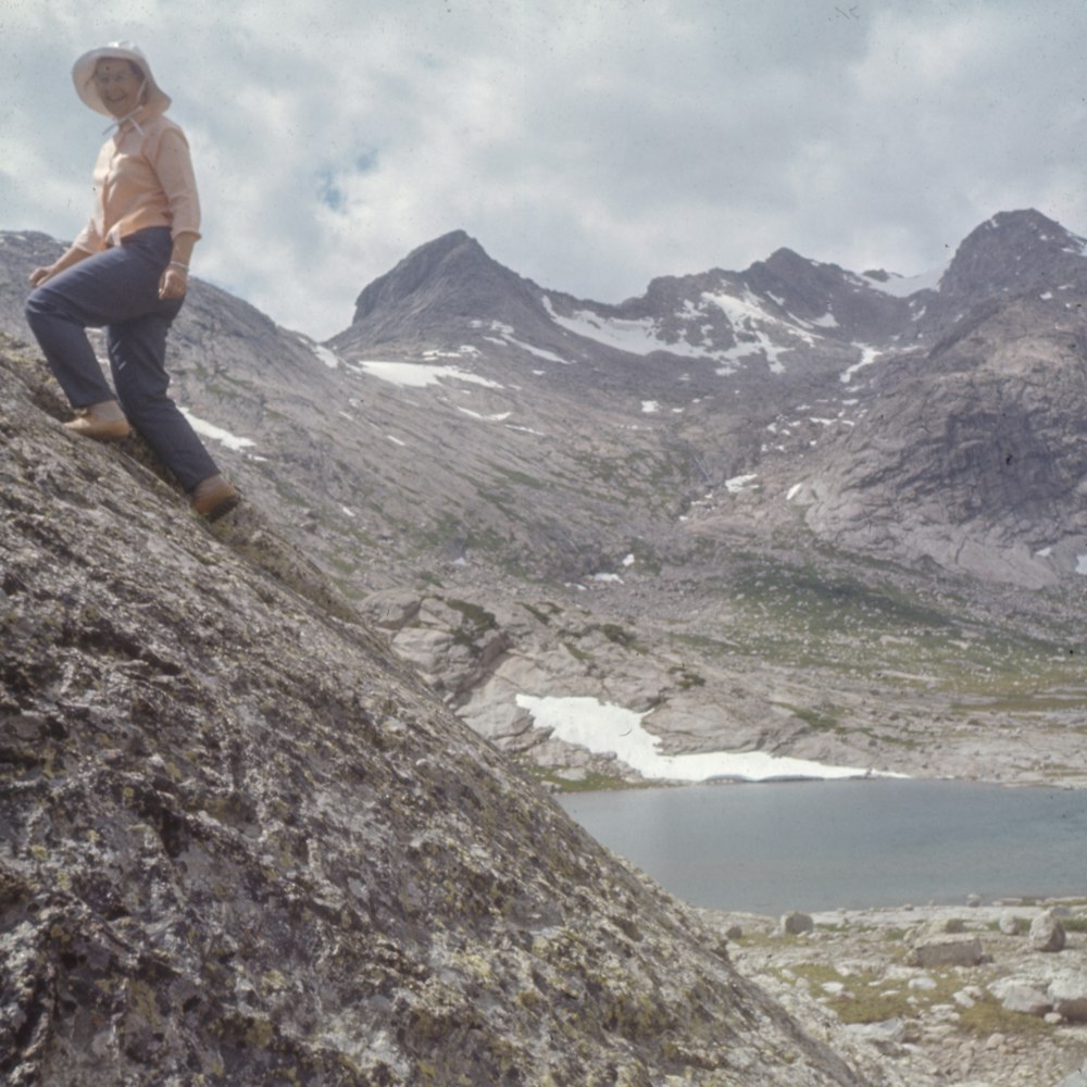 person standing on mountain cliff during daytime