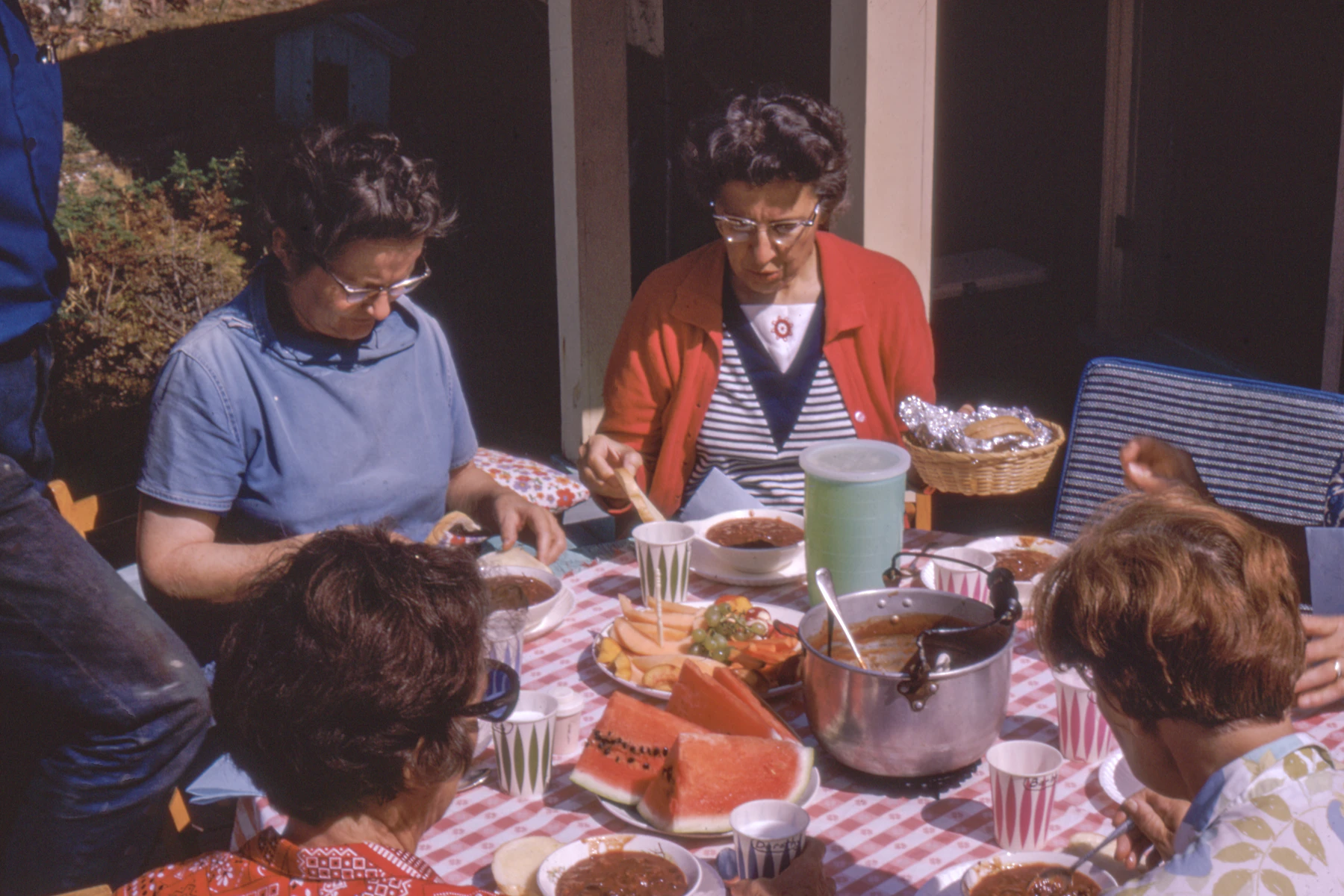 Women sitting beside a picnic table