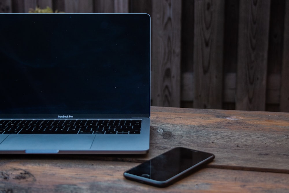 MacBook Pro beside space gray iPhone