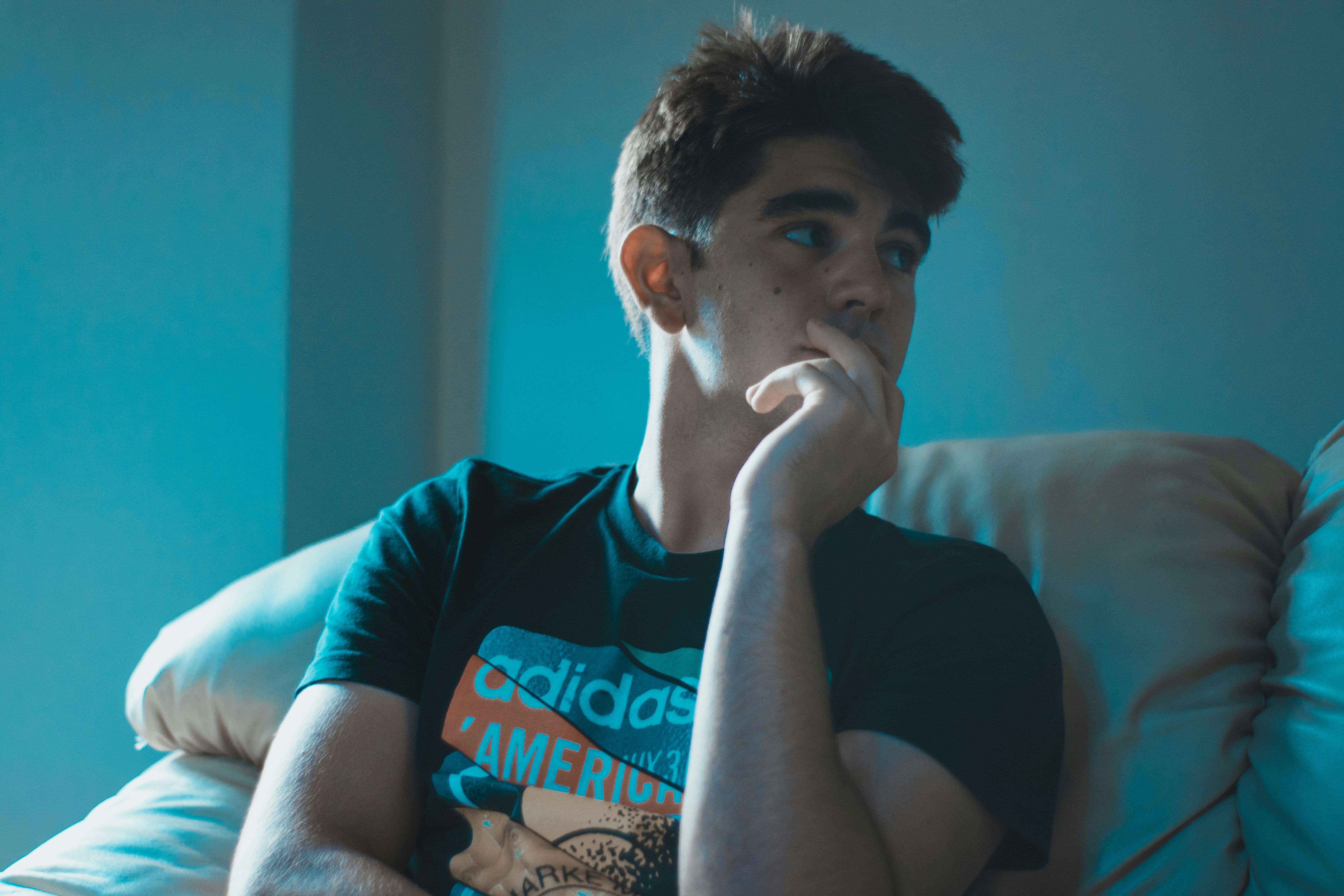 man wearing black shirt sitting on sofa