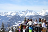 A group of travelers sharing a meal around a wooden table in a mountain cabin.