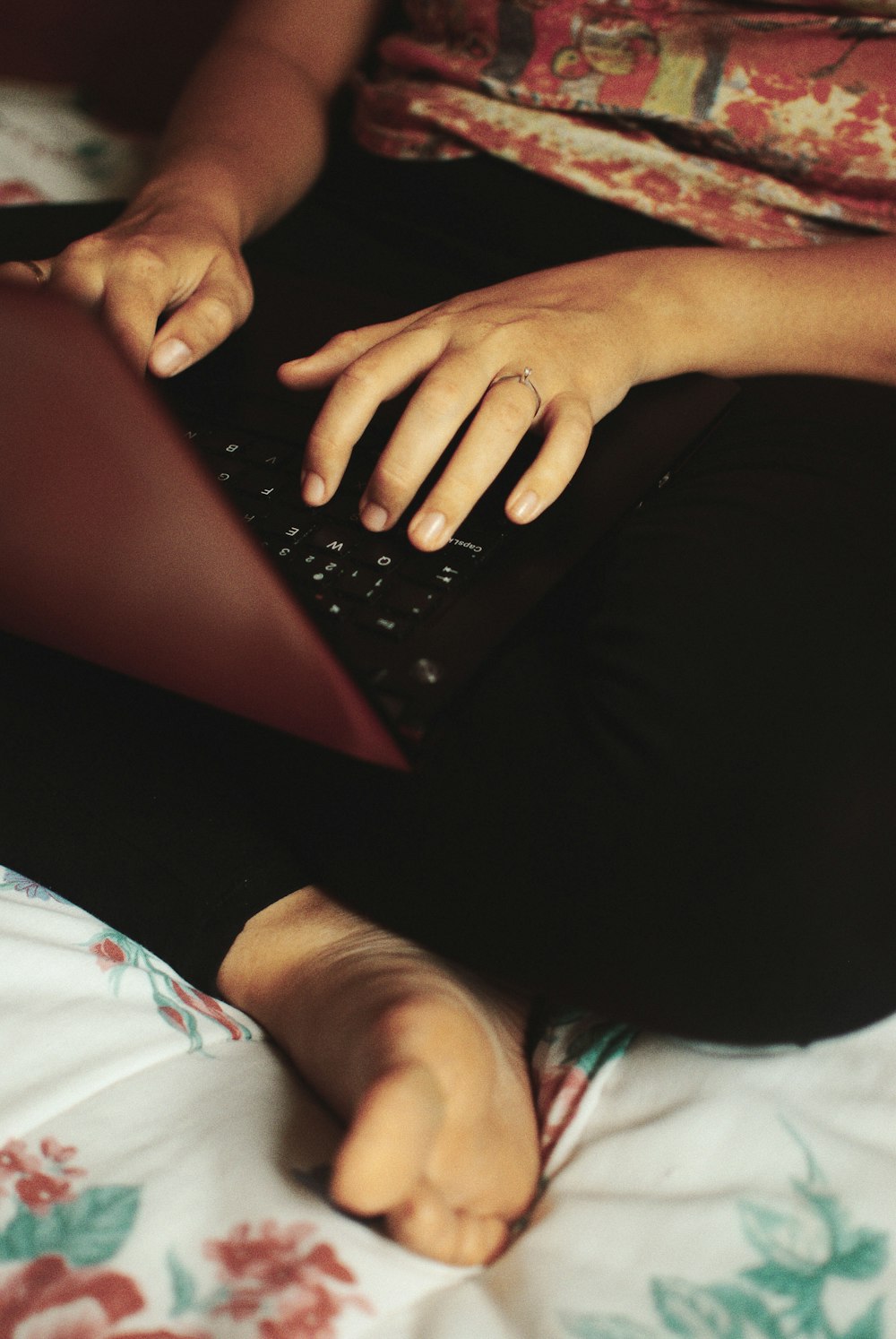 person sitting on bed while using laptop