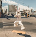 person in rabbit mascot jumping near road side