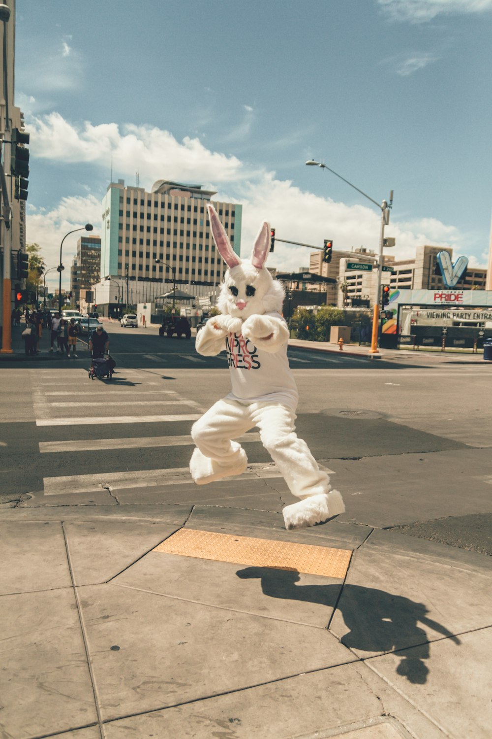 Persona en mascota de conejo saltando cerca del lado de la carretera