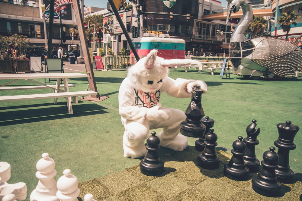 Persona che indossa il costume da coniglio che gioca a scacchi in formato ascensore