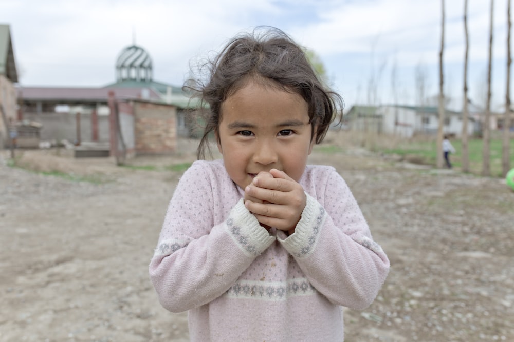 girl standing wearing pink sweater