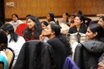 group of women sitting on chair while listening