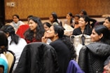 group of women sitting on chair while listening