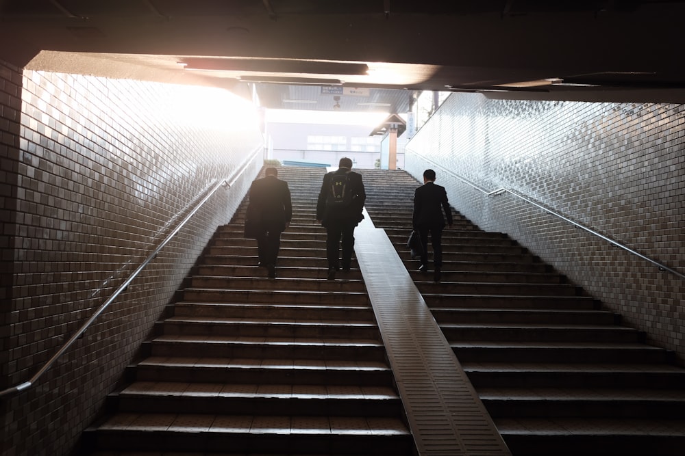 three man walking on stair