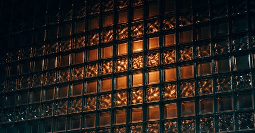 Close-up of a sleek glass block wall reflecting natural light.