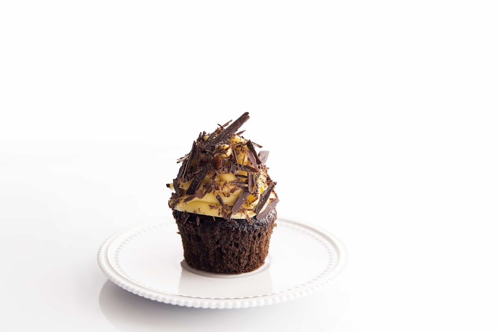 brown and white cupcake on round white ceramic plate