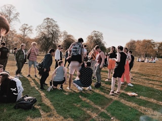 A diverse group of volunteers interacting with community members in a park.