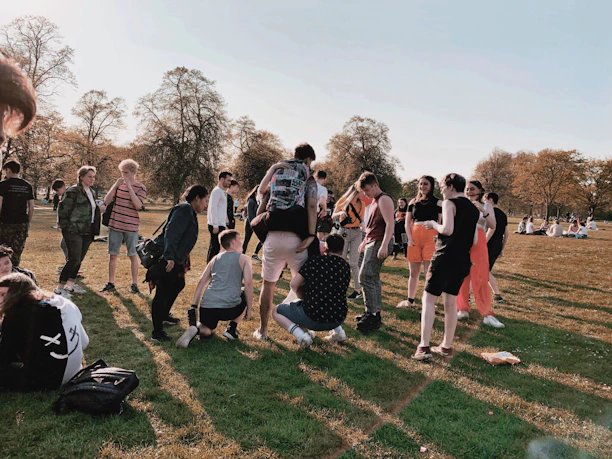 A warm group of social workers engaging with community members in a neighborhood park.