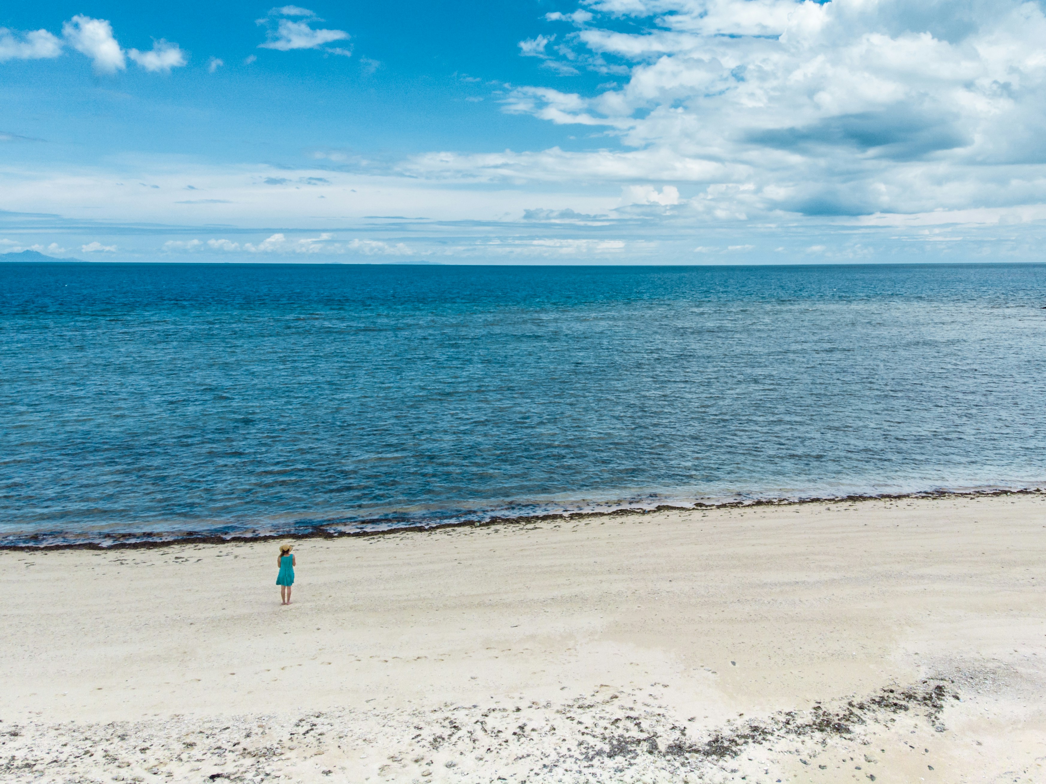 woman standing on shore near ocean during daytime fiji teams background