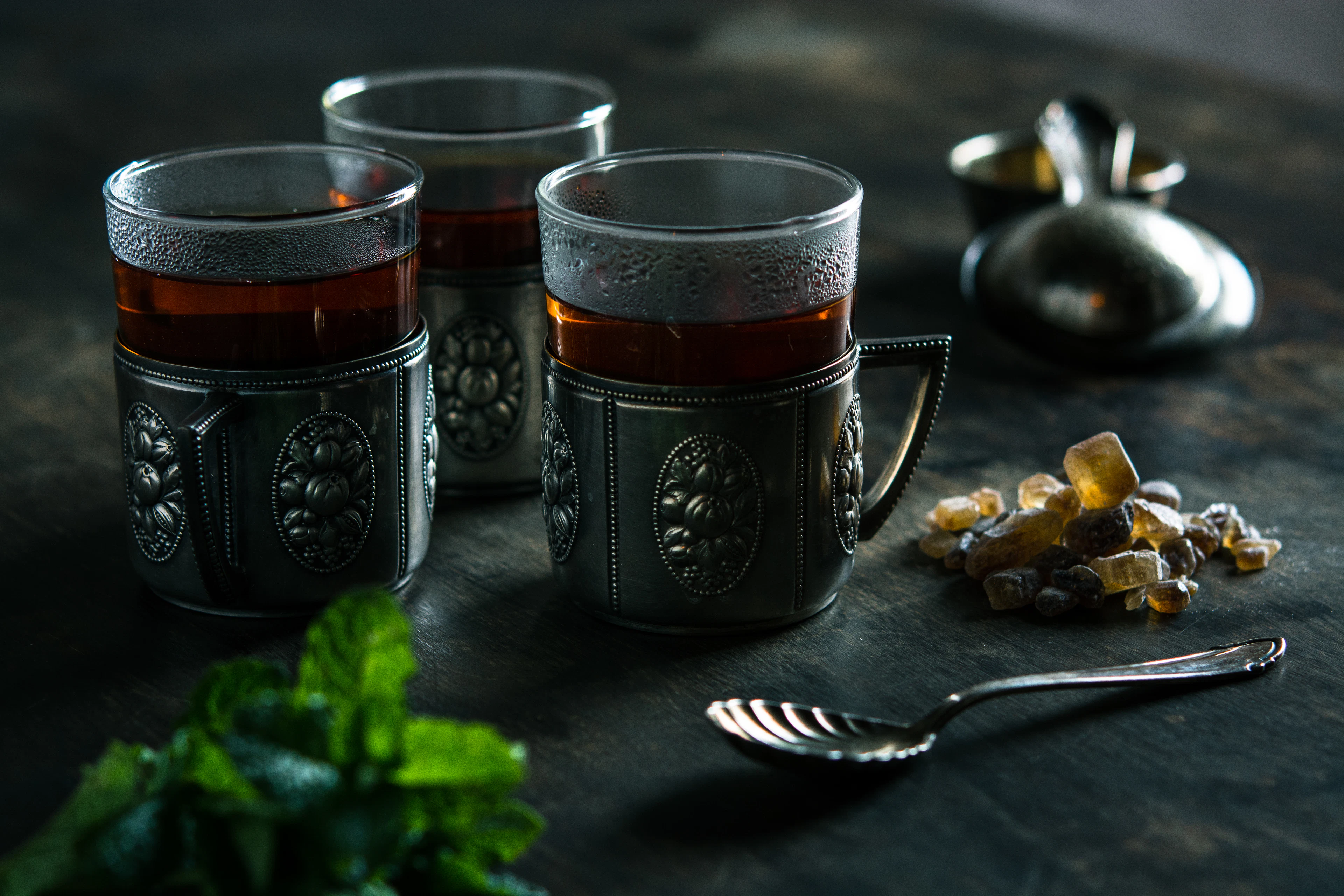 Glasses of mint tea and a silver teapot on a tray