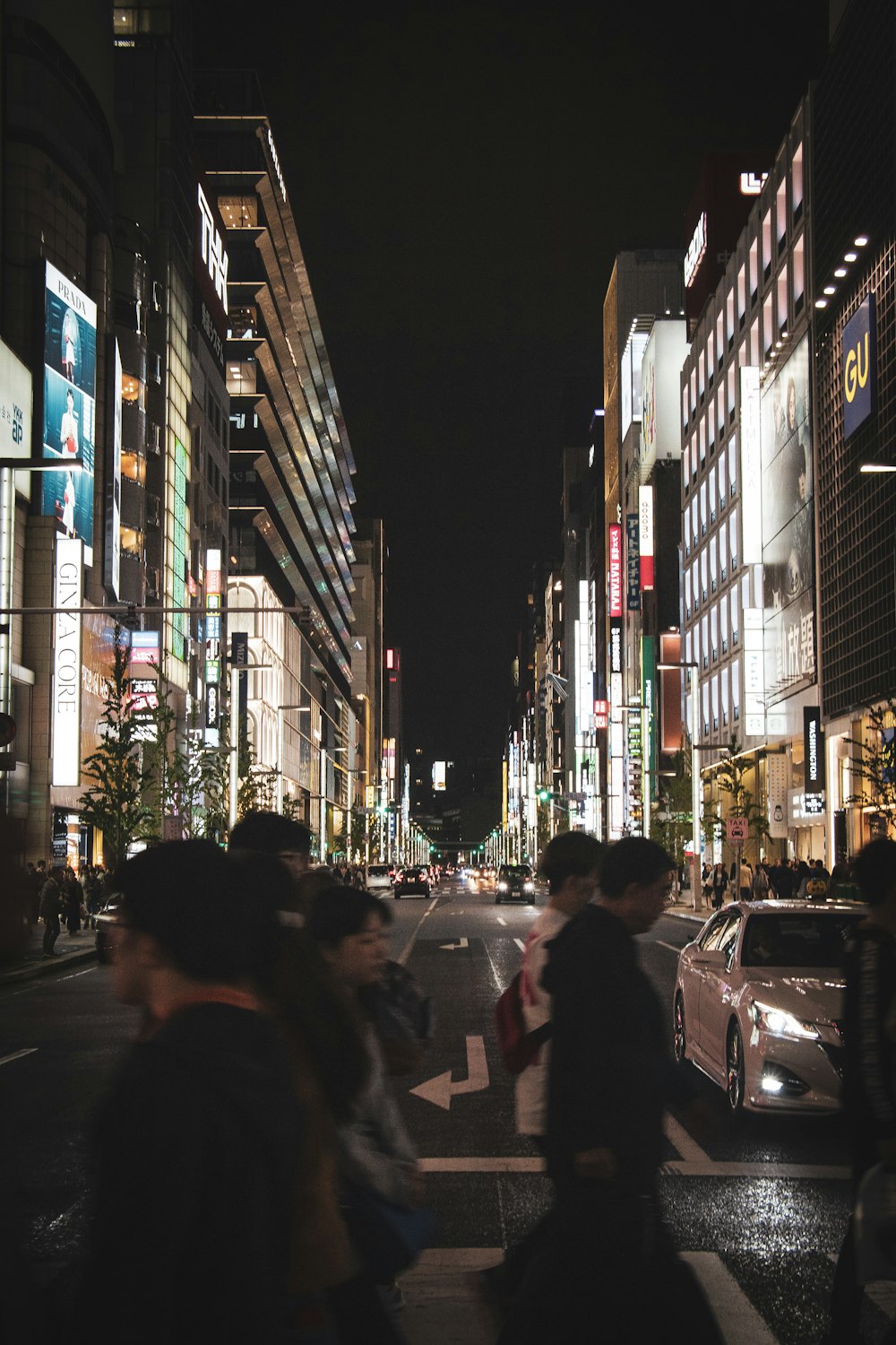 Personas que pasan por los edificios de la ciudad durante la noche