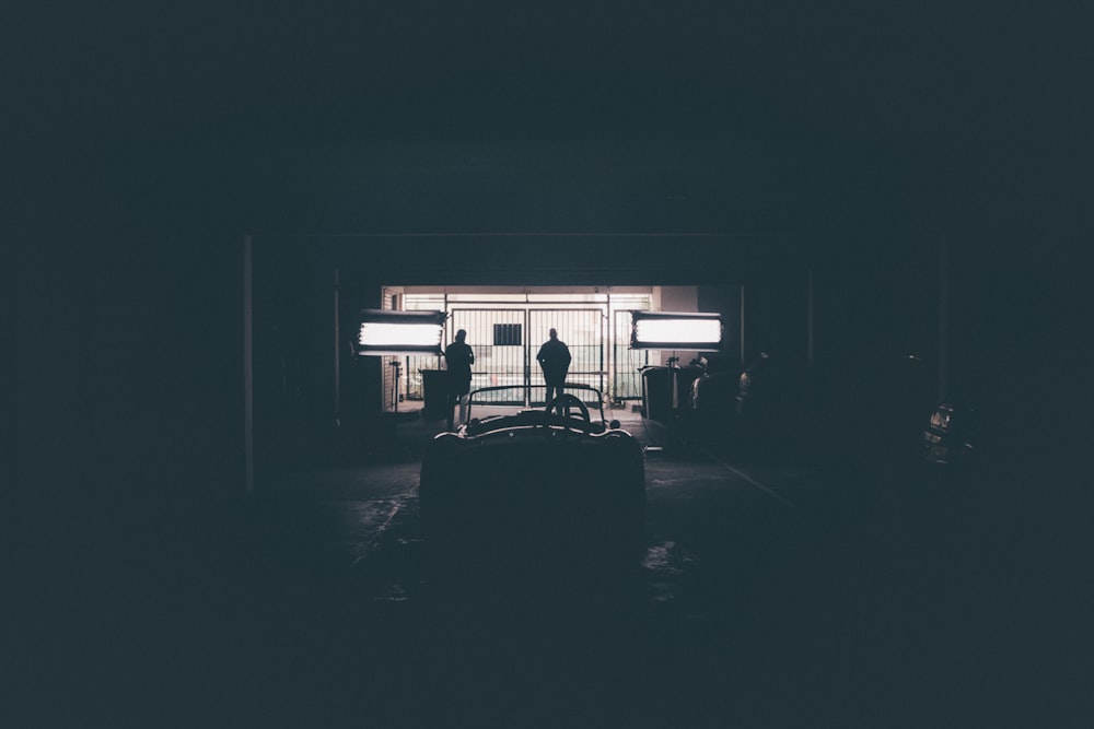 a person standing in a dark room with a suitcase