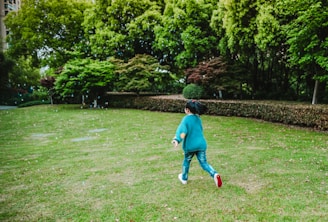 A joyful child running outdoors wearing colorful shoes supplied by antataa.