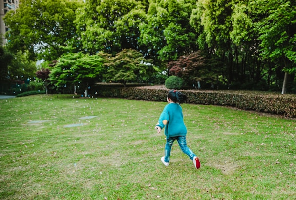 A joyful child running outdoors wearing colorful shoes supplied by antataa.
