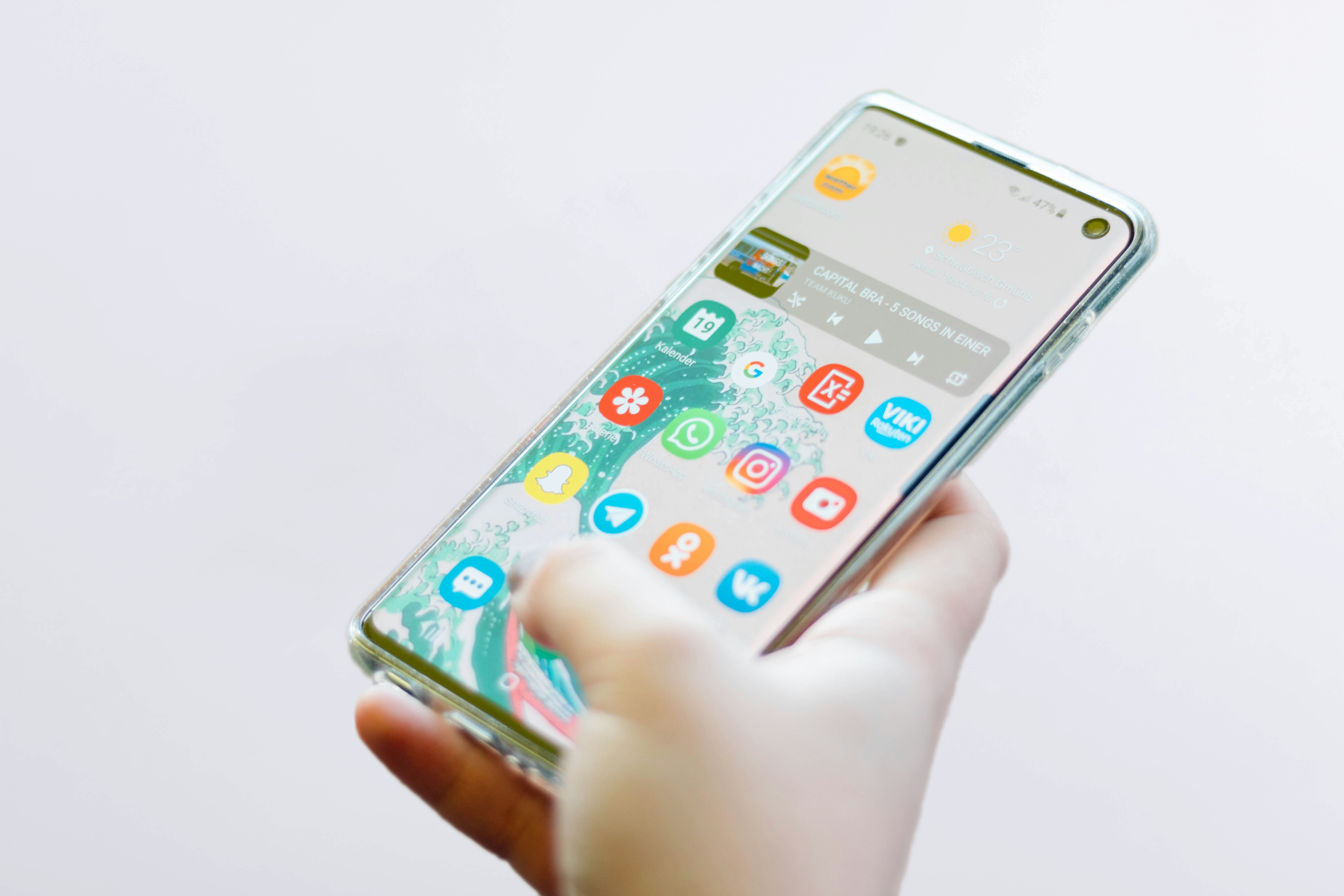 Hand holding modern Android smartphone running software update screen