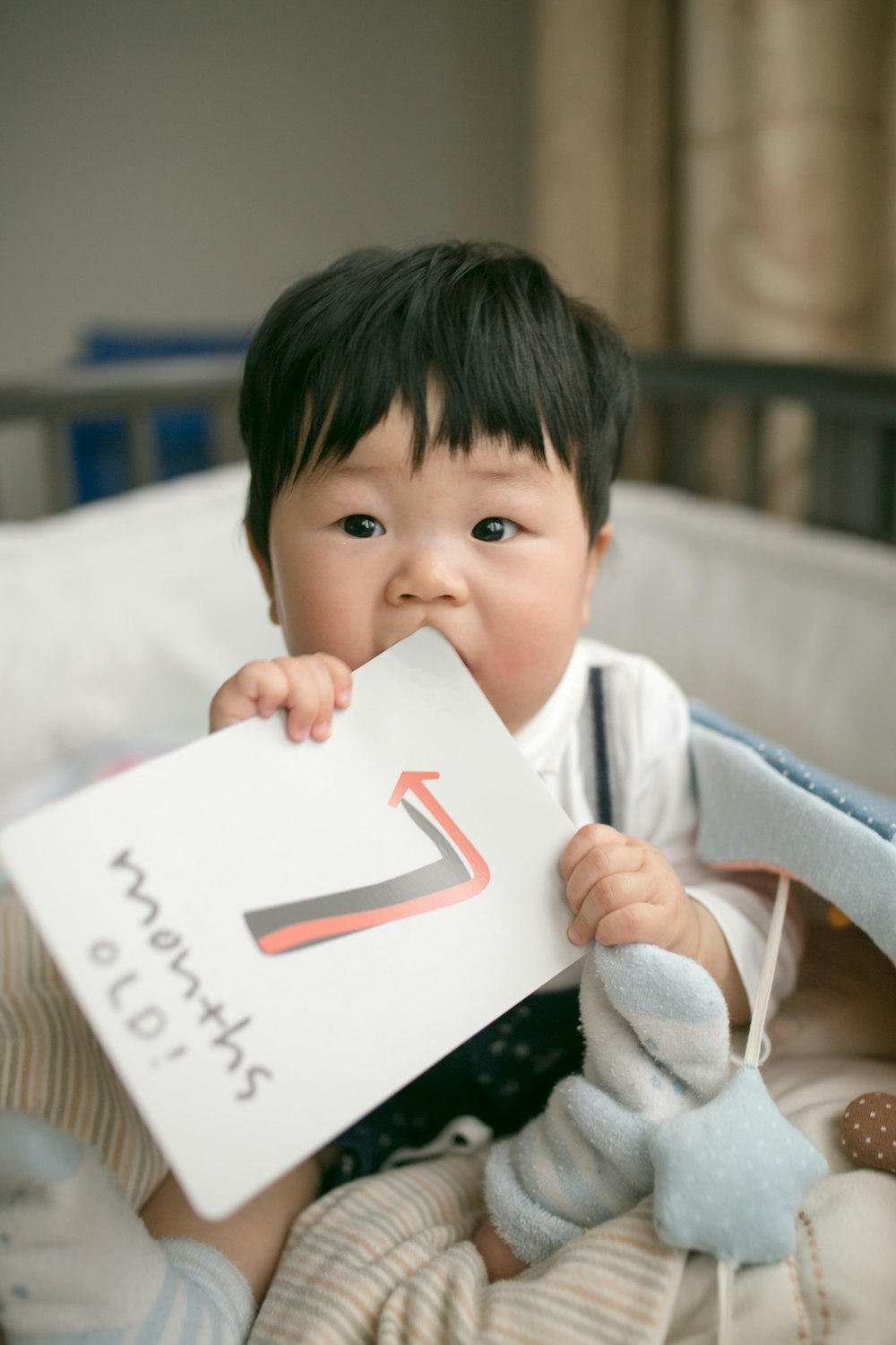 niño sosteniendo la tarjeta de meses de antigüedad