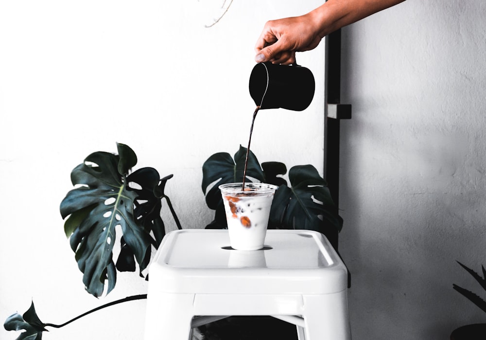 person pouring coffee on mug