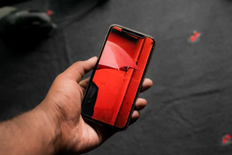 Close-up of a hand holding a smartphone showing a dripping faucet icon symbolizing crypto drip rewards.