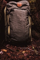 A close-up of durable, eco-conscious outdoor gear resting on a mossy forest floor.
