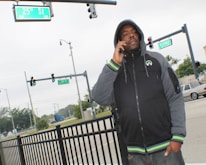 A credible messenger speaking with local youth on a city street corner.