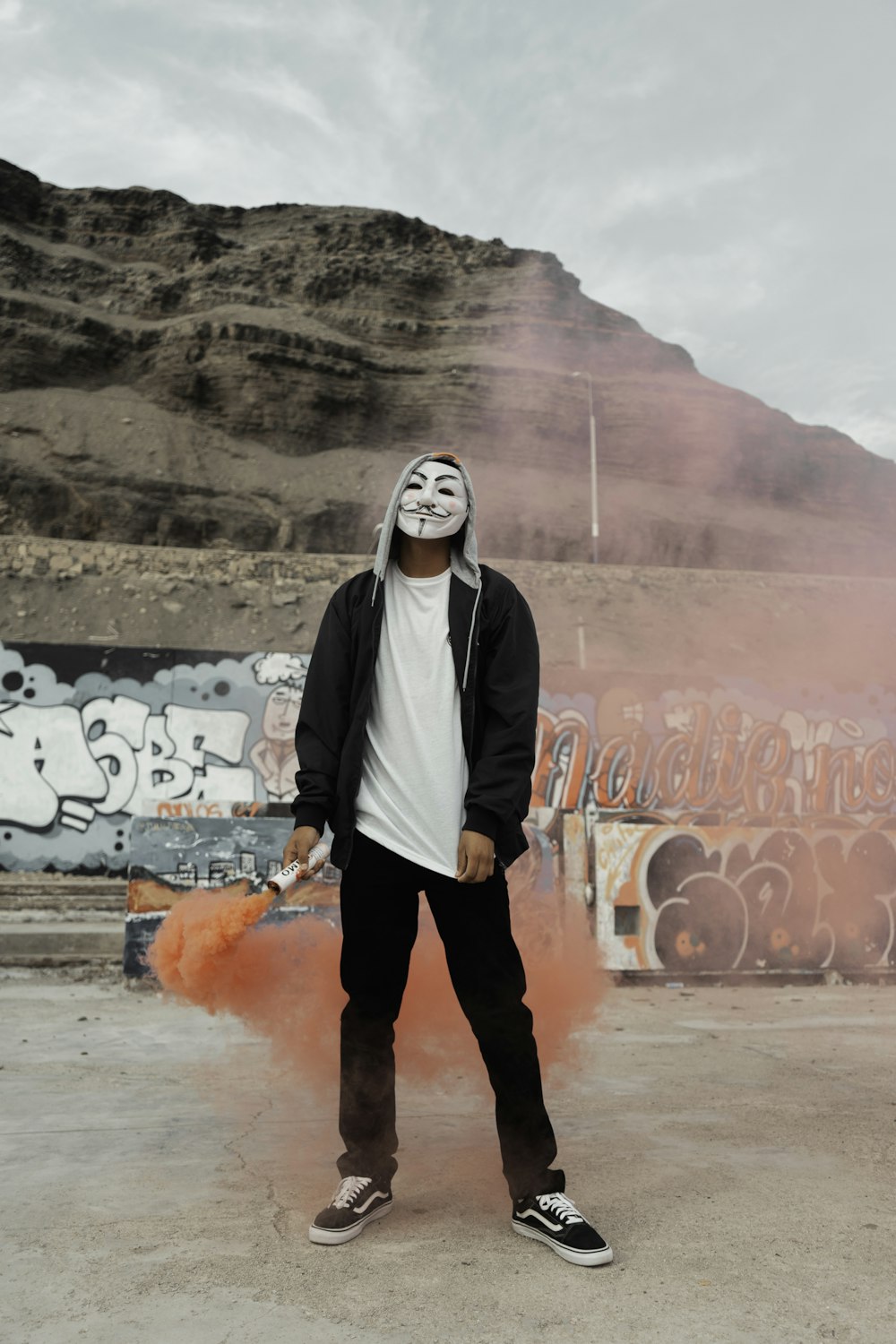 a man wearing a mask standing in front of a wall