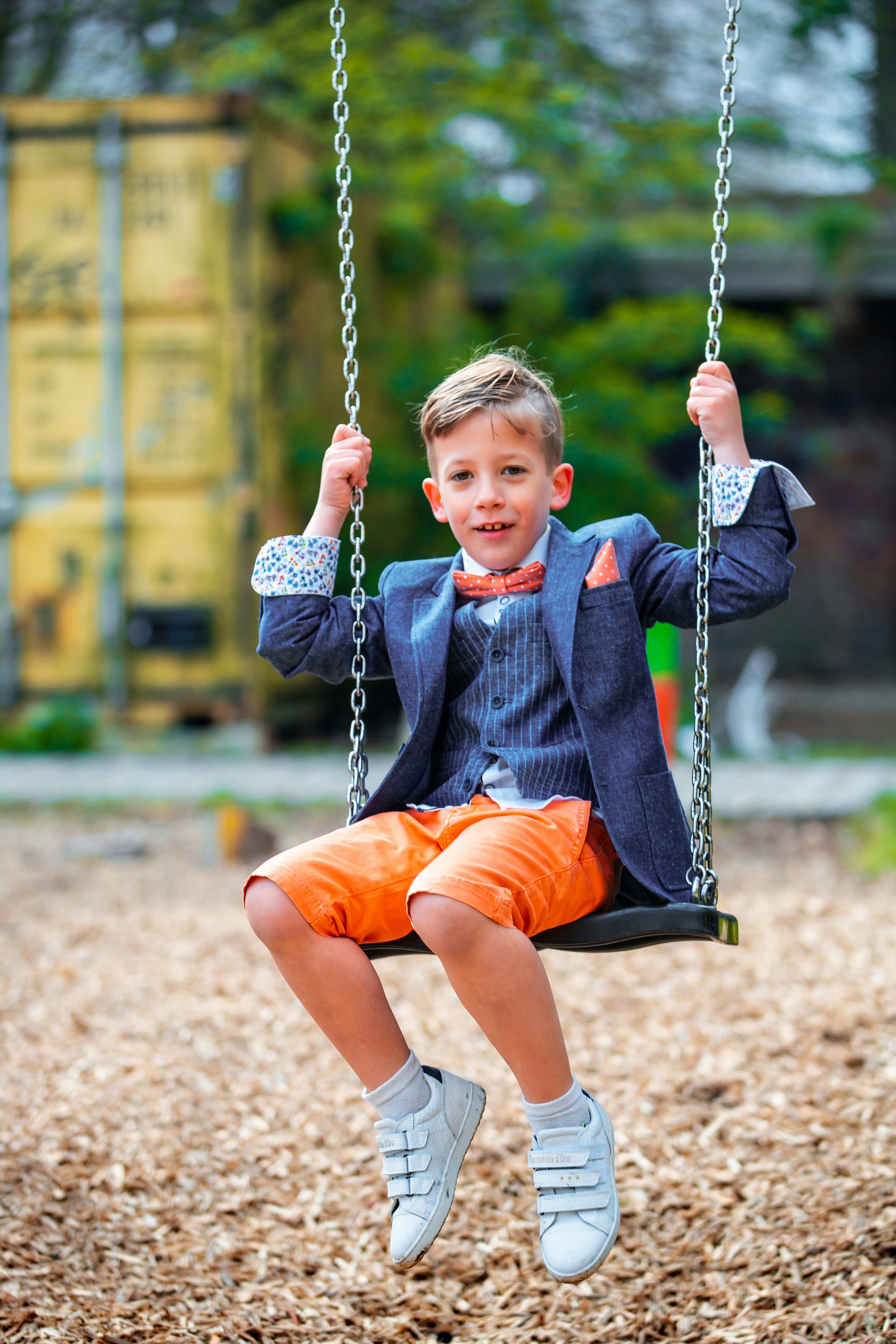 boy in pinstriped suit jacket on swing