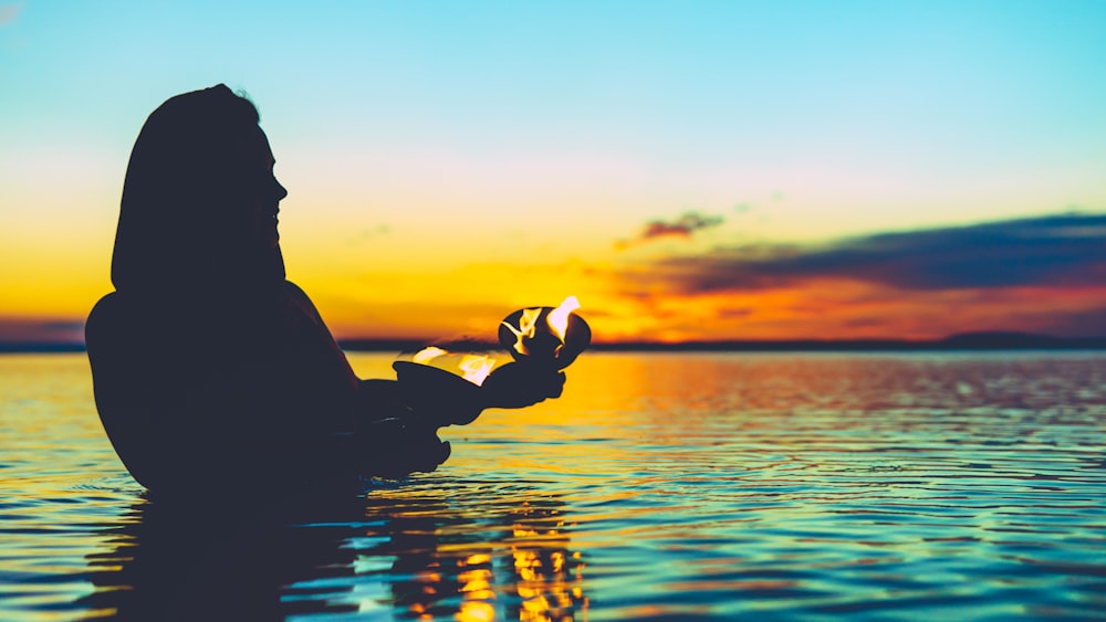 person in body of water holding pot