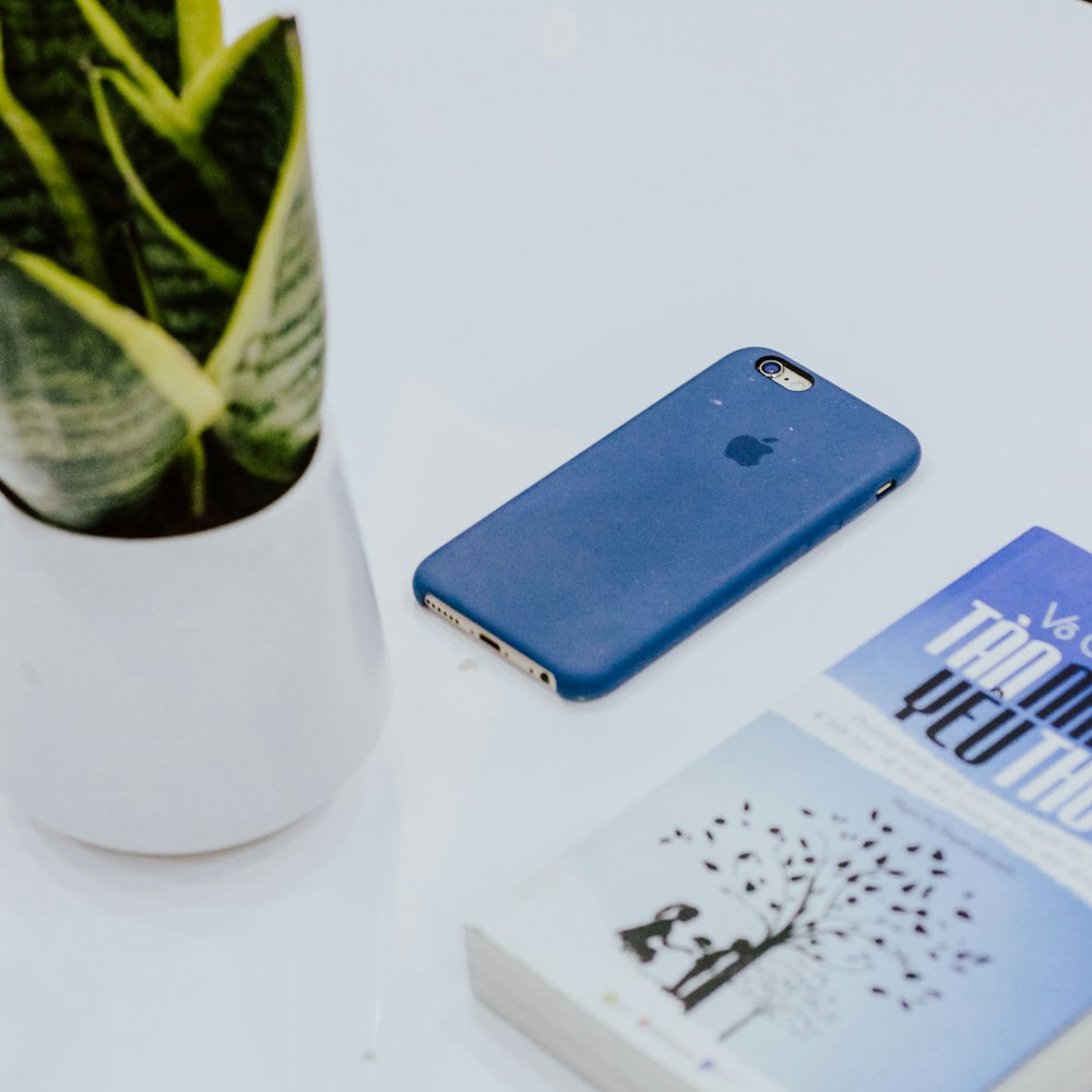 silver iPhone 6 beside book