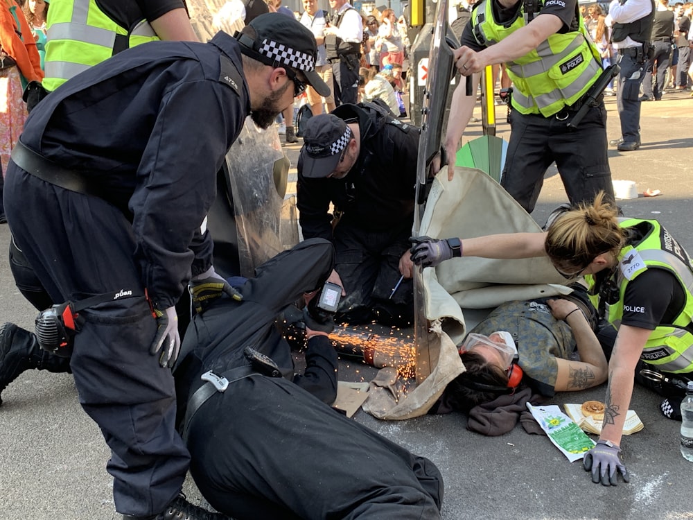 people rescuing man lying on ground