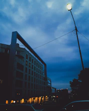 A dramatic 3D exterior render of a contemporary building under moody evening skies.