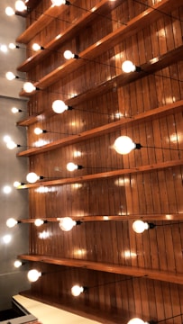 Industrial setting with UV coating application on wooden panels under bright lamps.